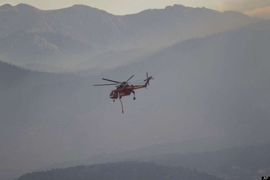 A helicopter heads out for a drop to battle the Waldo Canyon Fire north and west of Colorado Springs, Colo., on Wednesday, June 27, 2012. The wildfire doubled in size overnight to about 24 square miles (62 square kilometers), and has so far forced mandatory evacuations for more than 32,000 residents. (AP Photo/David Zalubowski)