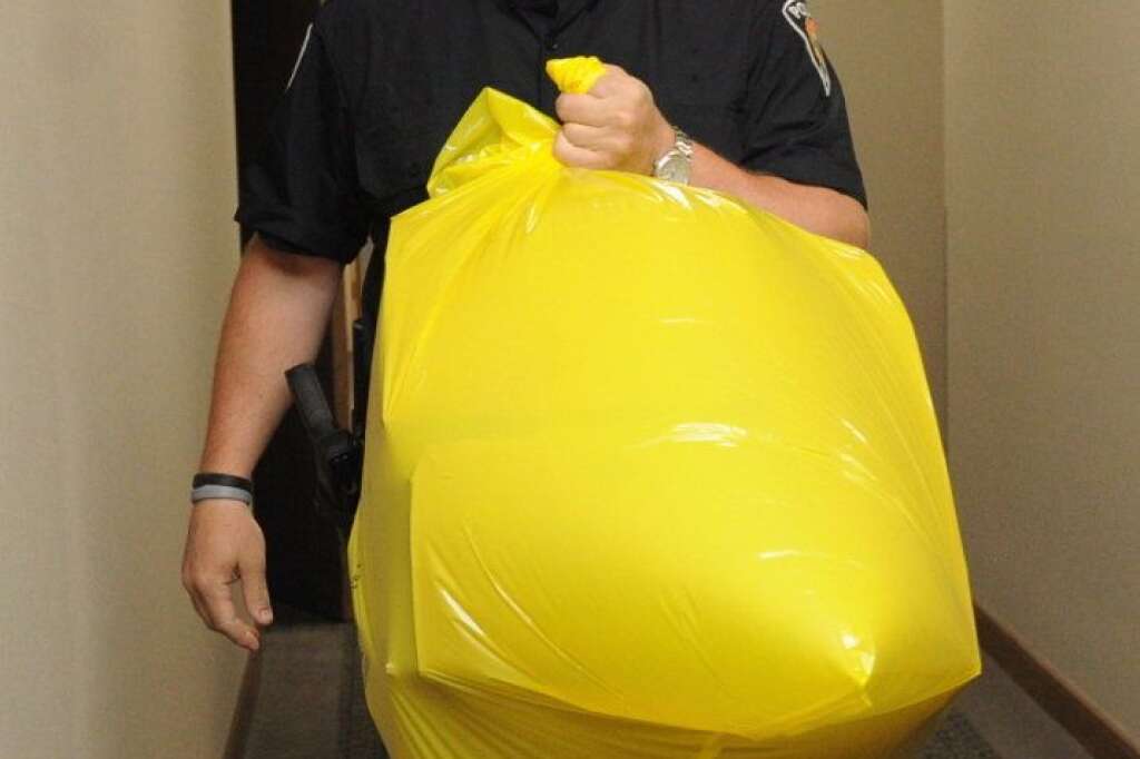 - Un policier de la GRC transporte dans un sac le colis livré aux bureaux du Parti conservateur, à Ottawa, qui contenait un pied. (PC/Sean Kilpatrick)