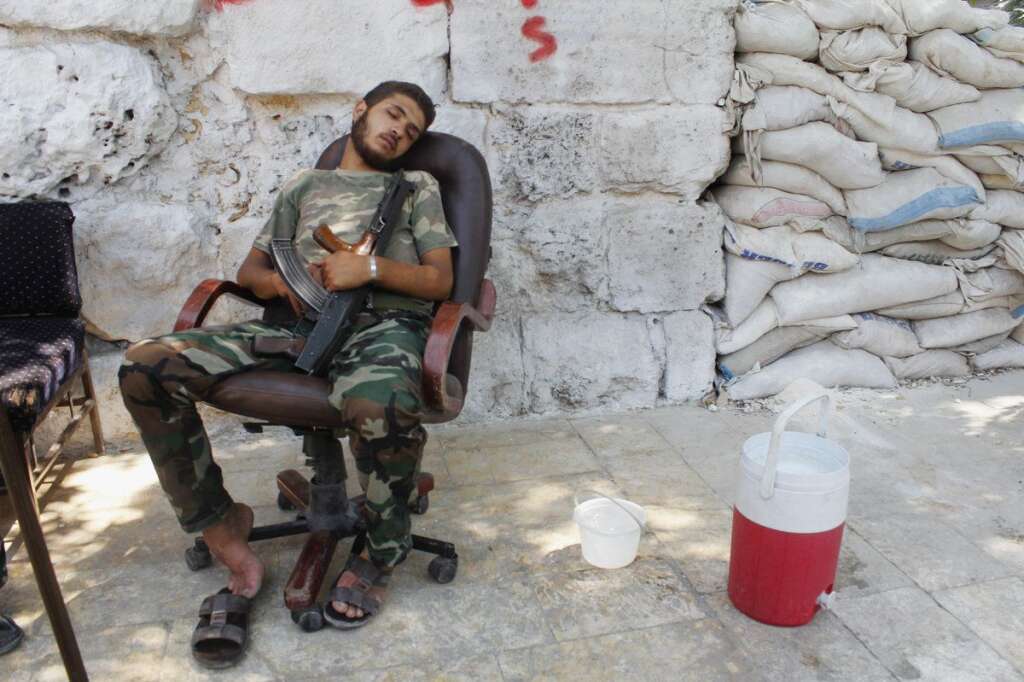 - Un rebelle, endormi, son arme contre lui. Alep, le 25 août 2013.
