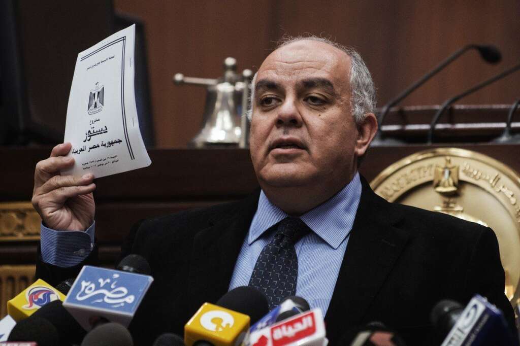 Au coeur du problème, le projet de constitution... - Le secrétaire général de l'Assemblée constitutionnelle égyptienne Amr Darrag  tenant dans sa main le projet de constitution. Les opposants reprochent notamment à la nouvelle Constitution de ne pas garantir les droits des minorités.