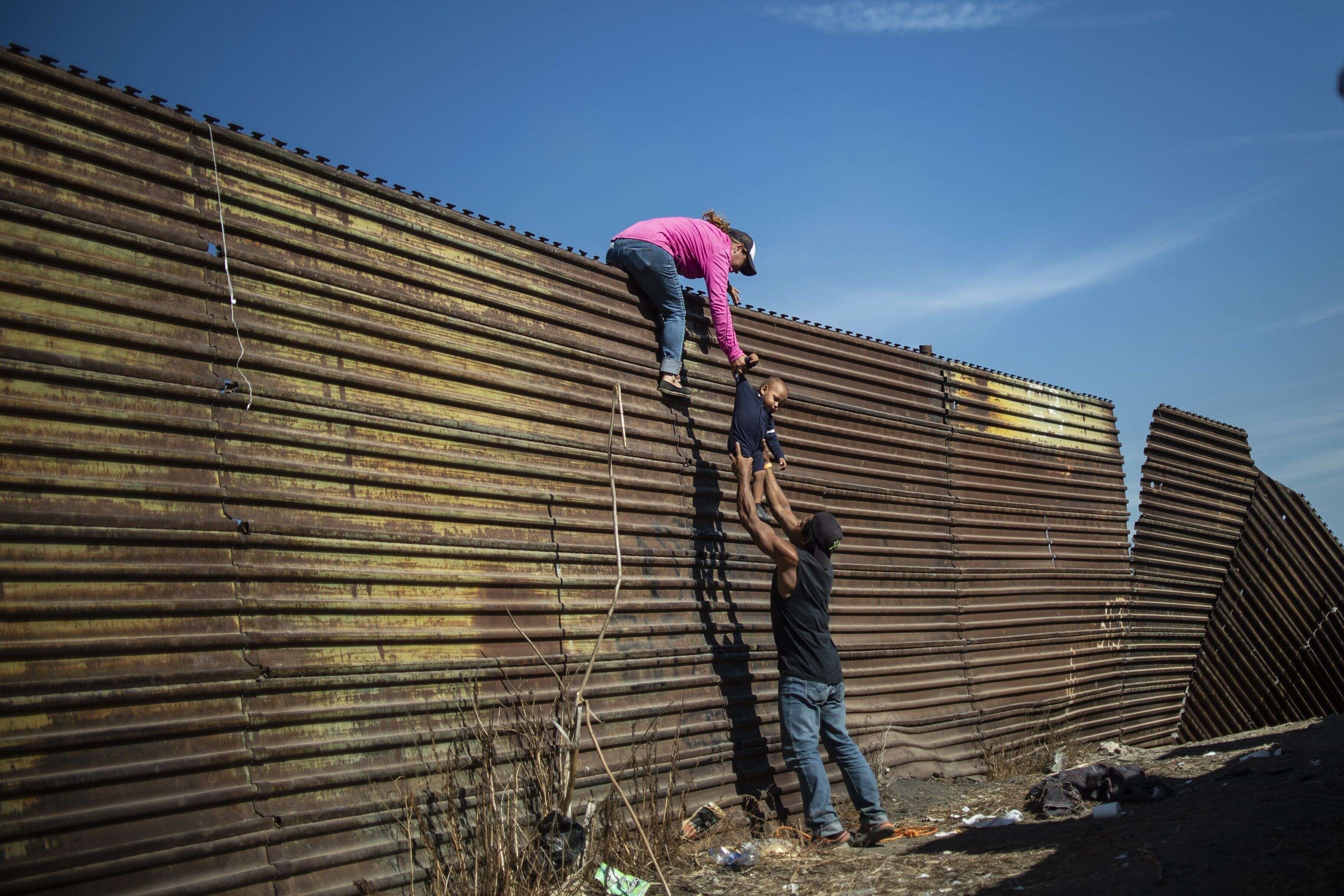 25 novembre - Des migrants d'Amérique centrale escaladent un mur près du passage frontalier d'El Chaparral, à Tijuana au Mexique.
