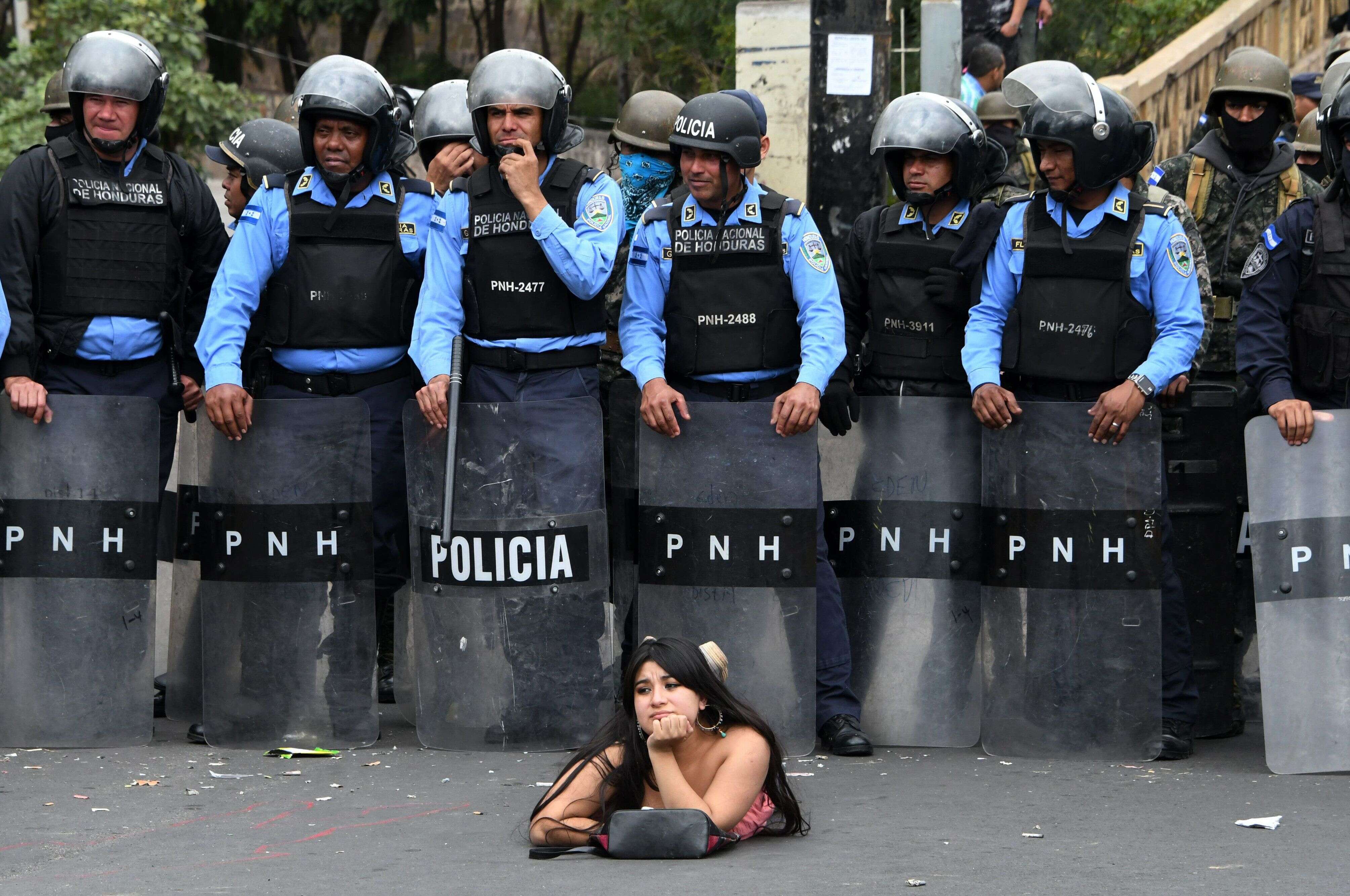 21 janvier - Une supportrice de Salvador Nasralla, candidat à la présidence de l'Alliance contre la dictature au Honduras, dans la rue devant des policiers lors d'une manifestation contre la réélection contestée du président Juan Orlando Hernandez à Tegucigalpa.