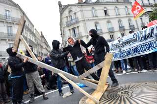 Protestors carry an effigy of French President Emmanuel Macron during a demonstration calling for a union between French rail agent and student protest movements in Nantes, western France, on April 7, 2018. / AFP PHOTO / LOIC VENANCE