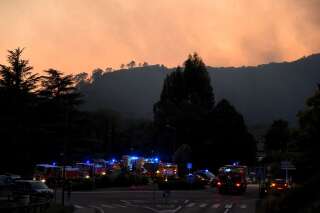 Des véhicules de pompiers rassemblés alors qu'un incendie fait rage sur la colline derrière la ville de Bessèges, dans le Gard, le 7 juillet 2022.