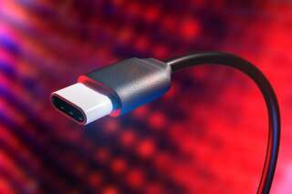 Conceptual rendering of a USB type C connection cable with detail of plug. USB-C allows faster data transfers, video communication and battery charging all in one compact plug. Red and blue abstract electronic background.