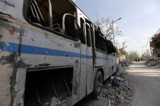 Un bus détruit près des décombres du Centre de recherches visé par les frappes à Damas, le 14 avril.