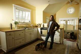 J.D. Doliner stands in the kitchen of her Arlington, Va., home, Tuesday, April 19, 2005. Doliner and her husband hired a contractor to redesign the home making it more environmentally friendly. The couple uses solar panels to generate a portion of their electricity and hot water, and Doliner said everything in their house was designed with the environment in mind, including the peace sign shaped widow at top right. (AP Photo/Haraz Ghanbari)