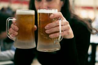 Happy woman drinks a lot of beer in mugs in such a funny alcoholic situation
