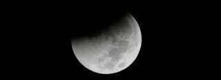Earth starts its shadow on the moon during a complete lunar eclipse over Saturday Aug. 28, 2018 in Jakarta, Indonesia. Curiosity and awe have greeted a complete lunar eclipse, the longest one of this century.  (AP Photo/Tatan Syuflana)