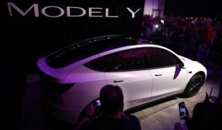 Attendees take photographs of the Tesla Inc. Model Y crossover electric vehicle during an unveiling event in Hawthorne, California, U.S., on Friday, March 15, 2019. Tesla Chief Executive Officer Elon Musk said the cheaper electric crossover sports utility vehicle (SUV) will be available from the spring of 2021. The vehicle's price will start at $39,000, a longer-range version will cost $47,000. Photographer: Patrick T. Fallon/Bloomberg via Getty Images