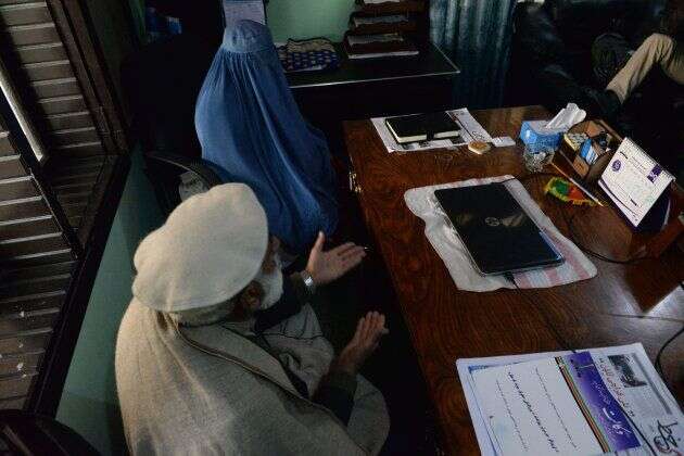 Nadia, dans le cabinet de son avocat, assise aux côtés de son père, pour demander le divorce d'avec son mari, à Jalalabad.