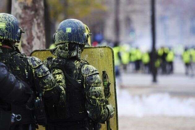 Sur les Champs-Élysées, les gilets jaunes aspergent les policiers de peinture jaune