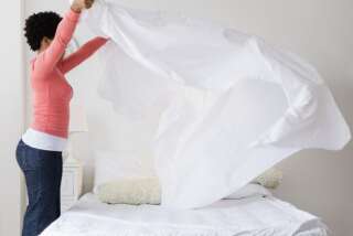Black woman making bed
