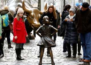 Des passants regardent la statue de la fillette, installée face à celle du taureau à New York, le mardi 7 mars.