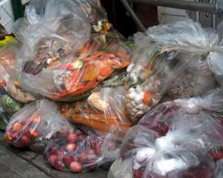 À l'extérieur d'une épicerie, les fruits et légumes frais côtoient les ordures.