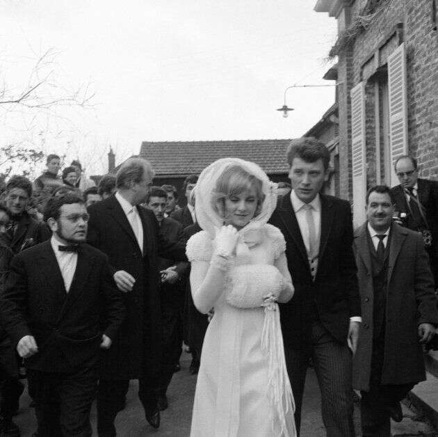 Sylvie Vartan et Johnny Hallyday tentent d'échapper  à leurs admirateurs avant d'entrer dans la petite élise où sera célébré leur mariage, le 12 avril 1965 à Loconville.