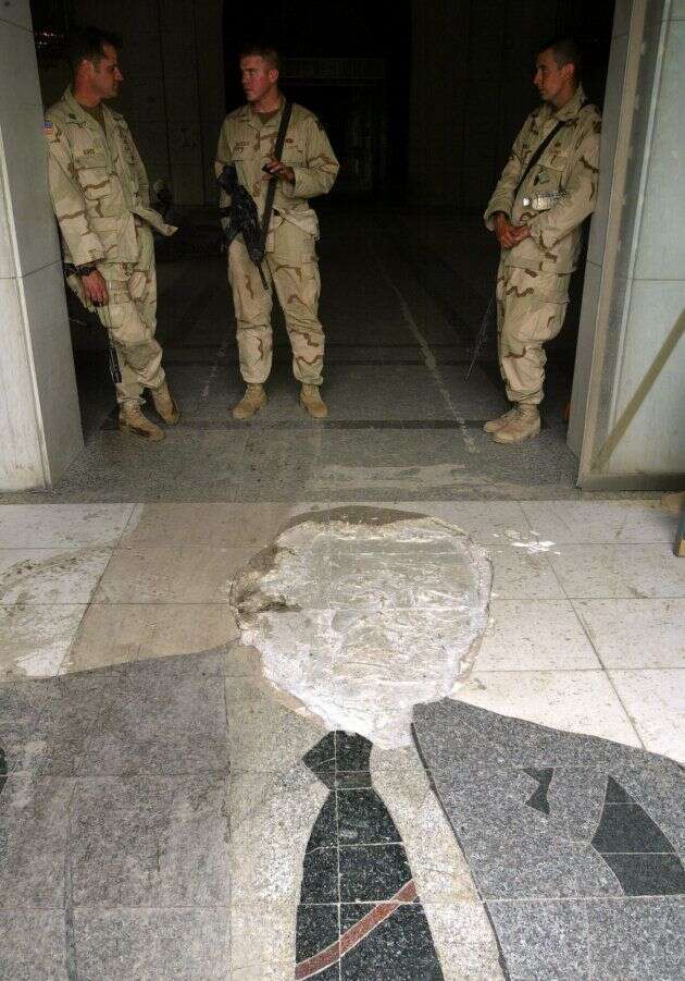 Des soldats américains devant la mosaïque de George Bush, déjà partiellement détruite en mars 2003.