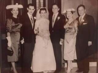 Bride Anita and Groom Pablo on their wedding day in 1957, posing with their parents. Anita wore a different wedding dress that was also made by her mother.