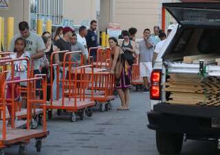 6 septembre 2017, à Miami: des habitants se préparant à l'arrivée d'Irma font la queue devant un magasin pour acheter des feuilles de contreplaqué.