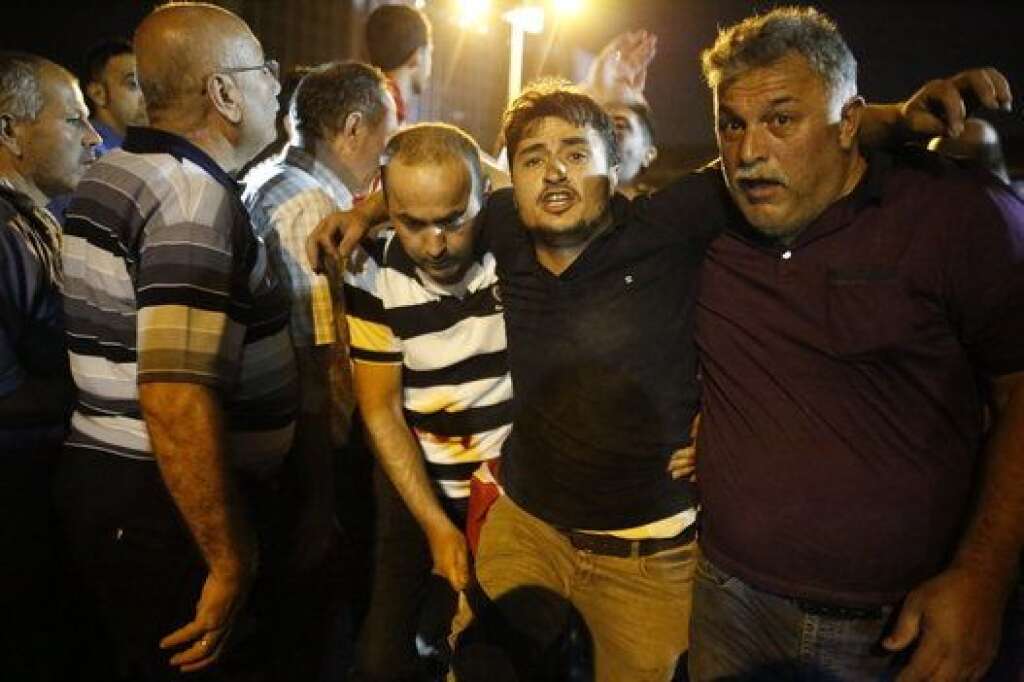 People help an injured man near the Taksim Square in Istanbul, Turkey, July 16, 2016. REUTERS/Murad Sezer