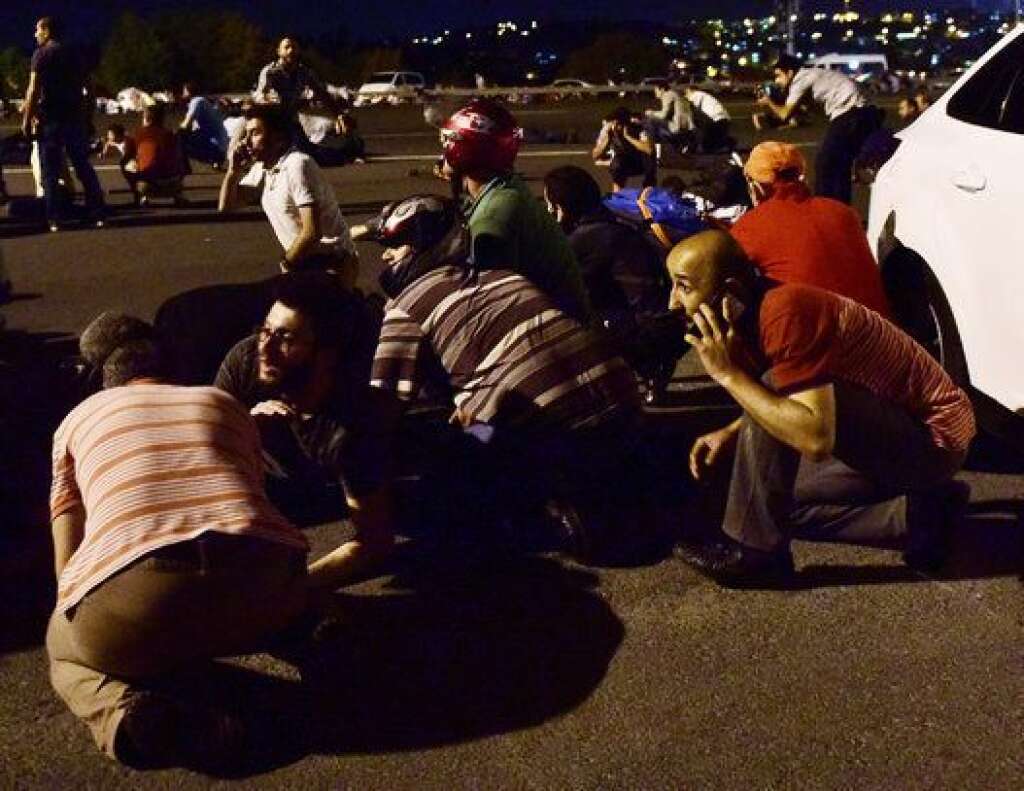 People take cover near a bridge during an attempted coup in Istanbul, Turkey July 16, 2016.     REUTERS/Yagiz Karahan