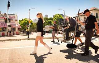 Margot Robbie, ses bottes blanches et les techniciens sur le tournage.
