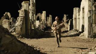 George MacKay, alias Schofield, dans les ruines d'un village abandonné du film 