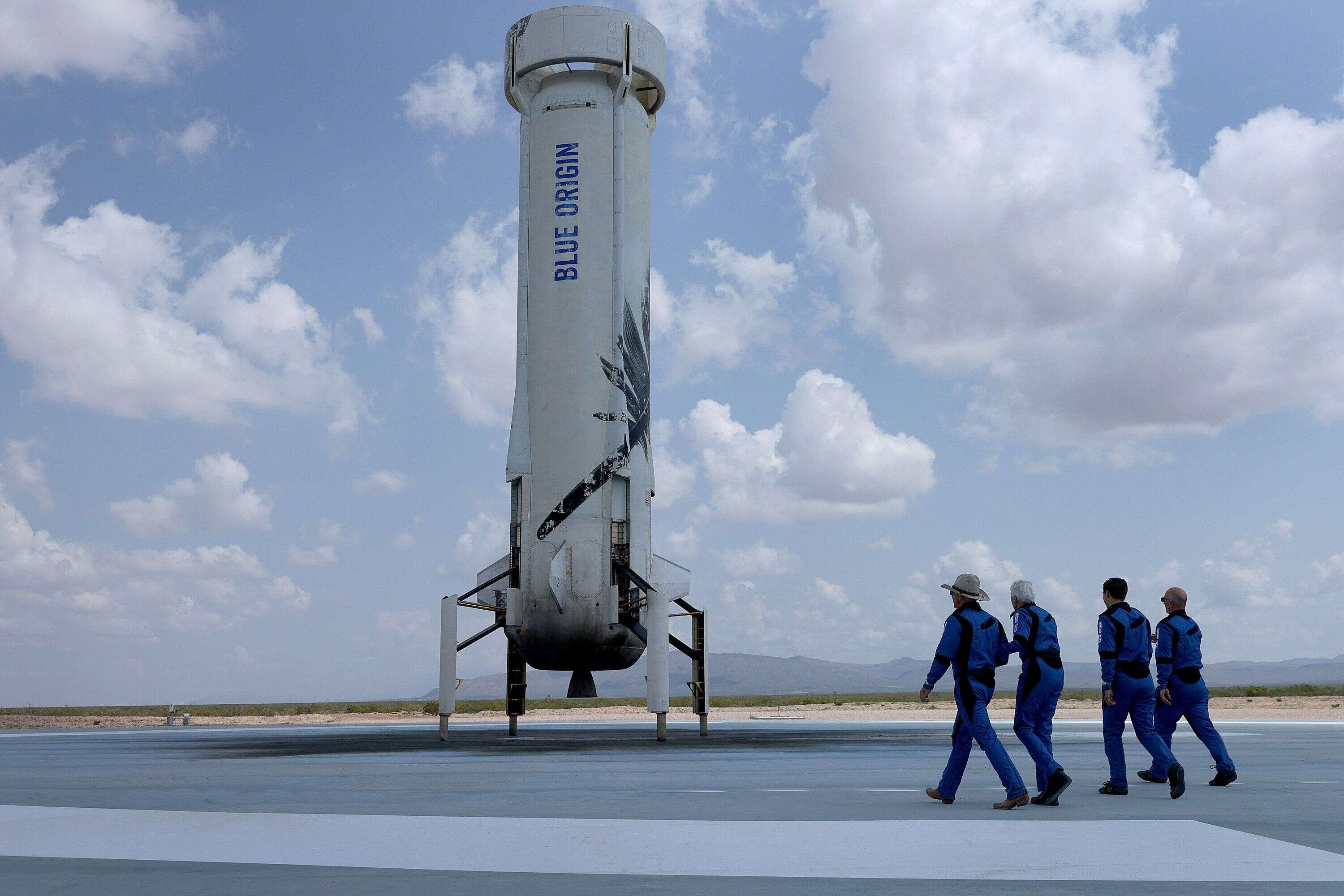 VAN HORN, TEXAS - JULY 20: Blue Origin's New Shepard crew (LR) Jeff Bezos, Wally Funk, Oliver Daemen, and Mark Bezos walk near the booster to pose for a picture after flying into space in the Blue Origin New Shepard rocket on July 20, 2021 in Van Horn, Texas.  Mr. Bezos and the crew were the first human spaceflight for the company.  (Photo by Joe Raedle/Getty Images)