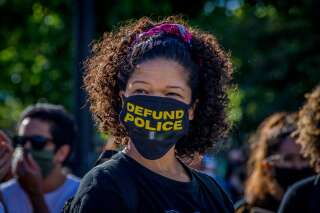 À New York, dimanche 7 juin, une manifestante arbore un masque contre le coronavirus orné du slogan 