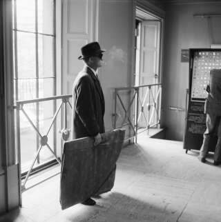 Un homme avec un cadre emballé lors de l'enquête des détectives de Scotland Yard à la National Gallery, peu après le vol en 1961