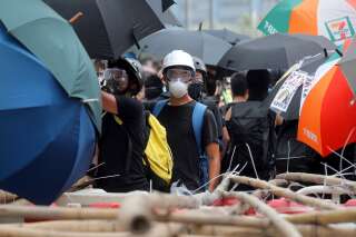 Un manifestant se tient près d’une barricade en tiges de bambou lors d’une manifestation à Hong Kong, le 24 août 2019.
