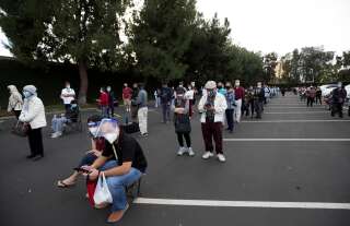 Des personnes attendant de recevoir leur injection du vaccin de Moderna sur le parking de Disneyland, à Anaheim en Californie, le 13 janvier 2021.