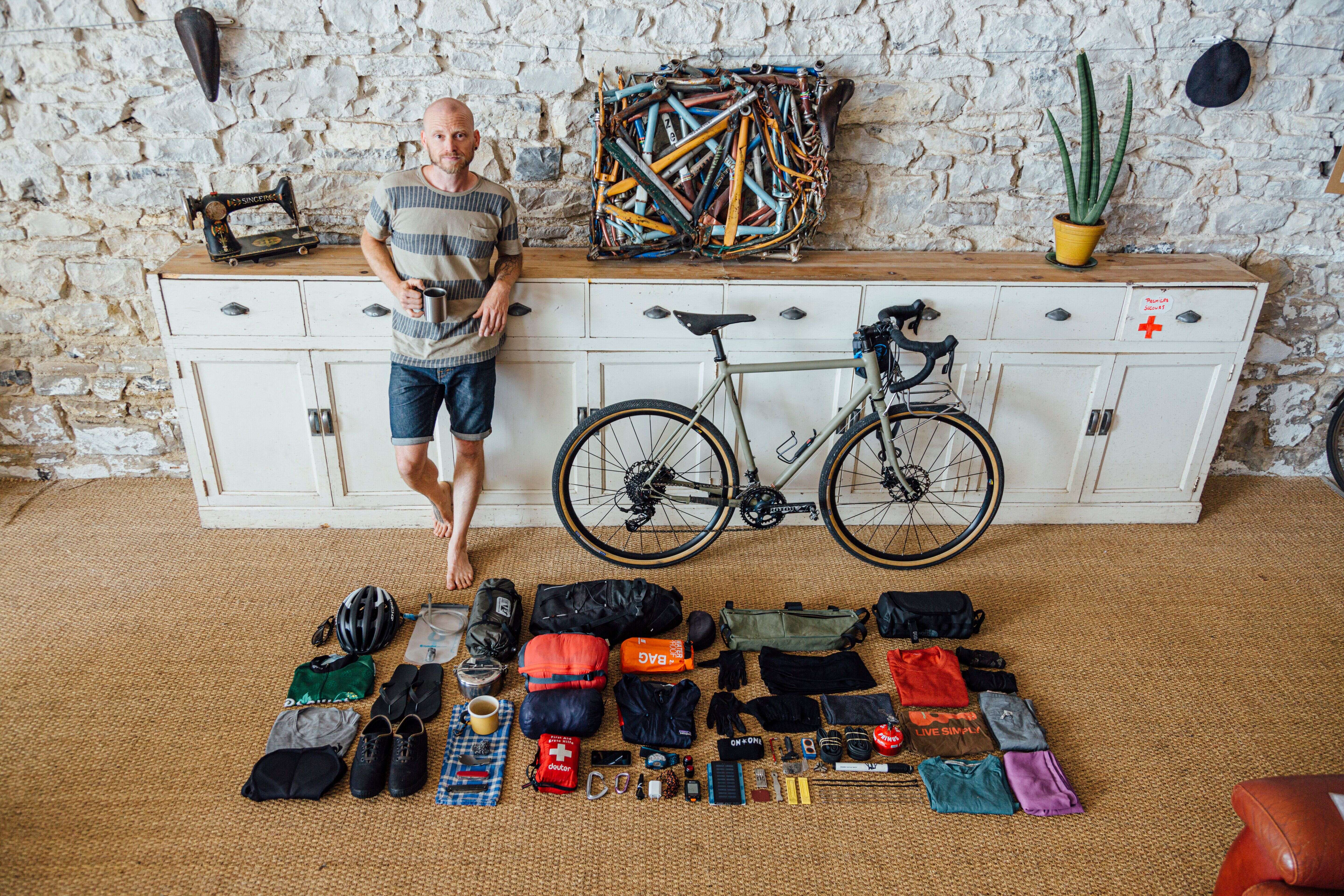 Laurent Belando et le nécessaire à mettre dans ses sacoches avant de partir en voyage à vélo.