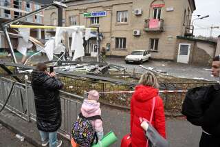 Des habitants près du lieu d'impact d'un obus russe à Kiev le 24 février 2022.