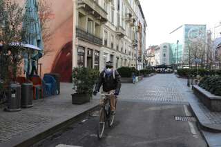 Un homme parcourt à vélo la Corso Garibaldi, une des artères principales du centre de Milan, désertée, le 26 février. En réaction à la pandémie, la ville prévoit l’aménagement de pistes cyclables et d’allées piétonnes pour dissuader les gens de circuler en voiture.