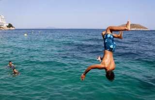 Un garçon plonge des falaises de la plage de Magaluf, à Majorque (Espagne), le 30 juillet. La région est très prisée des touristes, surtout britanniques.