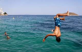 Un garçon plonge des falaises de la plage de Magaluf, à Majorque (Espagne), le 30 juillet. La région est très prisée des touristes, surtout britanniques.
