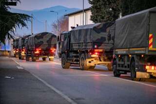 Des camions militaires italiens parcourent les rues de Bergame, en Italie, le 18 mars, suite au déploiement de l'armée pour transporter des cercueils de la ville aux provinces voisines en raison du débordement des pompes funèbres.