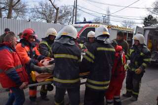 Des secouristes évacuant une personne des décombres après la frappe russe à Mykolaïv le 29 mars 2022.