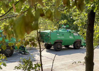 Armored vehicles of the police are seen near Grunewald forest in Berlin after a large fire broke out in the popular forest following an explosion in a police munitions storage site on August 4, 2022. - The affected area of 15,000 square metres (161,500 square feet) includes a storage site for police ammunition. (Photo by Lara BOMMERS / AFP)