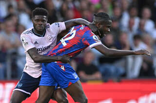 Arsenal's Ghanaian midfielder Thomas Partey (L) holds onto Crystal Palace's French striker Odsonne Edouard (R) during the English Premier League football match between Crystal Palace and Arsenal at Selhurst Park in south London on August 5, 2022. (Photo by JUSTIN TALLIS / AFP) / RESTRICTED TO EDITORIAL USE. No use with unauthorized audio, video, data, fixture lists, club/league logos or 'live' services. Online in-match use limited to 120 images. An additional 40 images may be used in extra time. No video emulation. Social media in-match use limited to 120 images. An additional 40 images may be used in extra time. No use in betting publications, games or single club/league/player publications. /