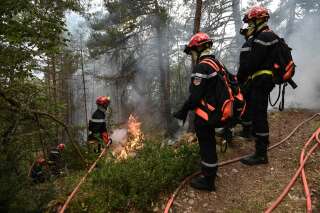 Firefighters light fires in Mostuejouls, southern France, on August 9, 2022,  as a prophylactic measure aimed at slowing the advance of a fire underway in the 