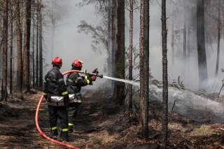 French firefighters spray water to put out lingering hot spots left by a wildfire near Belin-Beliet, southwestern France, on August 13, 2022. (Photo by Thibaud MORITZ / AFP) / “The erroneous mention appearing in the metadata of this photo by Thibaud MORITZ has been modified in AFP systems in the following manner: [Belin-Beliet] instead of [Belin-Belitet]. Please immediately remove the erroneous mention[s] from all your online services and delete it  from your servers. If you have been authorized by AFP to distribute it to third parties, please ensure that the same actions are carried out by them. Failure to promptly comply with these instructions will entail liability on your part for any continued or post notification usage. Therefore we thank you very much for all your attention and prompt action. We are sorry for the inconvenience this notification may cause and remain at your disposal for any further information you may require.”