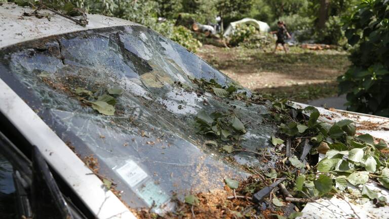 A destroyed car is parked in the Sagone camping site in Sagone, where a tree fell on a bungalow during storms killing one person on August 18, 2022, on the French Mediterranean island of Corsica. - The violent storms that have been hitting the French Mediterranean since August 16, 2022 left three people dead and several injured on August 18, 2022 in Corsica, where rescue operations are also being carried out at sea. (Photo by Pascal POCHARD-CASABIANCA / AFP)