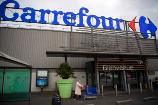 A woman enters a French retail giant Carrefour surpermarket, on January 13, 2021 in Saint-Herblain, outside Nantes. - Canadian convenience store group Alimentation Couche-Tard has approached France’s Carrefour about a takeover that would combine two retail groups jointly worth more than $50bn. 