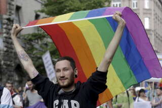 A man holds a rainbow flag as he walks during EuroPride 2015 in Riga, Latvia, June 20, 2015. Latvia is the first post-Soviet country to host EuroPride event.  REUTERS/Ints Kalnins