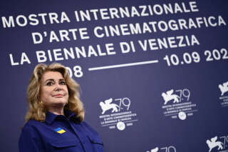 French actress Catherine Deneuve, wearing a flag of Ukraine on her shirt, poses on August 31, 2022, during a photocall for the Golden Lion for Lifetime Achievement she is to be awarded, on the opening day of the 79th Venice International Film Festival at Venice Lido. (Photo by Marco BERTORELLO / AFP)