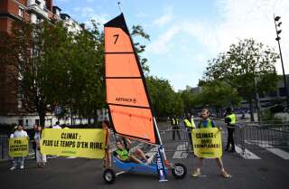 Greenpeace activists deploy a banner which reads 