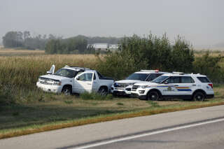 Royal Canadian Mounted Police vehicles are seen next to a pickup truck at the scene where suspect Myles Sanderson was arrested, along Highway 11 in Weldon, Saskatchewan, Canada, on September 7, 2022. - Canadian police said September 7, 2022 they arrested the second and final suspect over the stabbing spree that left 10 people dead and 18 wounded in a remote Indigenous community, two days after the first suspect was found dead. (Photo by LARS HAGBERG / AFP)