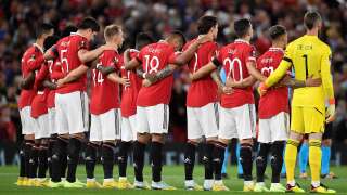 Manchester United players pause for a silence following the death of Queen Elizabeth II, ahead of the UEFA Europa League Group E football match between Manchester United and Real Sociedad, at Old Trafford stadium, in Manchester, on September 8, 2022. (Photo by Oli SCARFF / AFP)